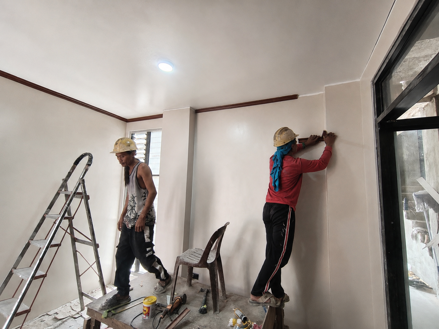 AEDO crew finishing interior wall trim on a residential project