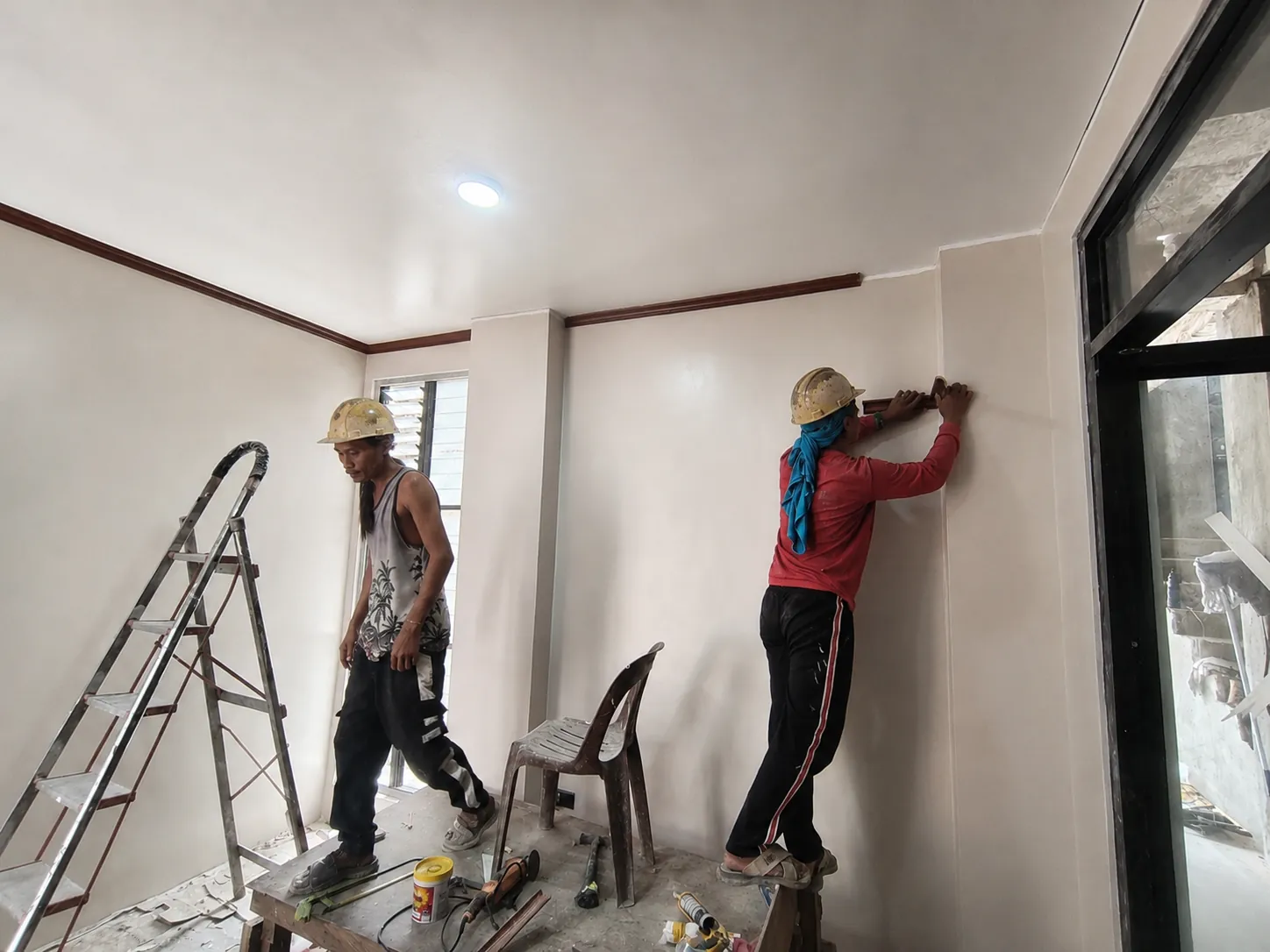 AEDO crew finishing interior wall trim on a residential project